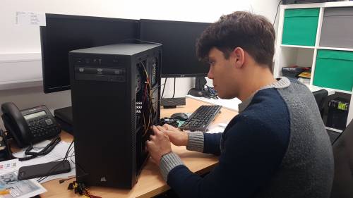 Computer engineer repairing a desktop computer